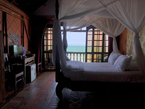 a bedroom with a bed with a view of the ocean at Full Moon Beach Resort in Mui Ne
