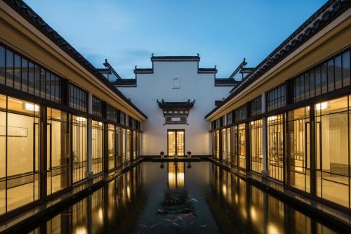 an empty corridor of a building with windows and water at Banyan Tree Huangshan in Huangshan