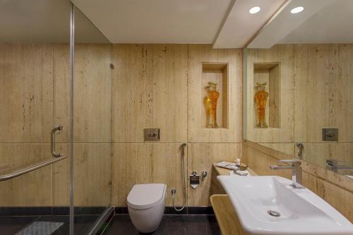 a bathroom with a toilet and a sink and a shower at Ramada by Wyndham Mussoorie Mall Road in Mussoorie