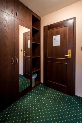 an empty room with a door and a green carpet at Hotel U Hejtmana Šarovce in Uherské Hradiště
