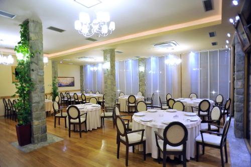 a banquet hall with tables and chairs in a room at Hotel Aria in Podgorica