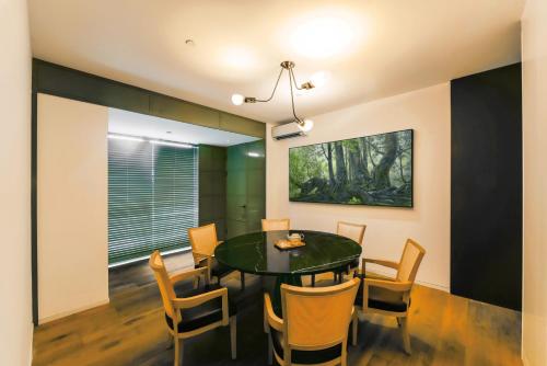 a dining room with a green table and chairs at Hotel Kapok Shenzhen HouHai (Close to Shenzhen Bay) in Shenzhen