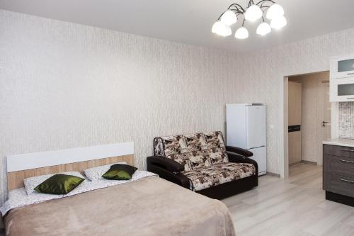 ノヴォシビルスクにあるApartament Antonina near by Marriott hotelのベッドルーム1室(ベッド1台、椅子、ソファ付)