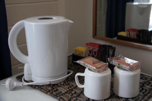 a white coffee maker on a counter with two cups at Lockleys Hotel in Adelaide