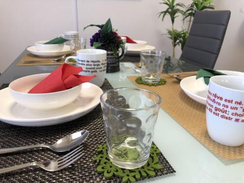a table with plates and bowls and a glass on it at TerraceRin YN31 in Tomigusuku