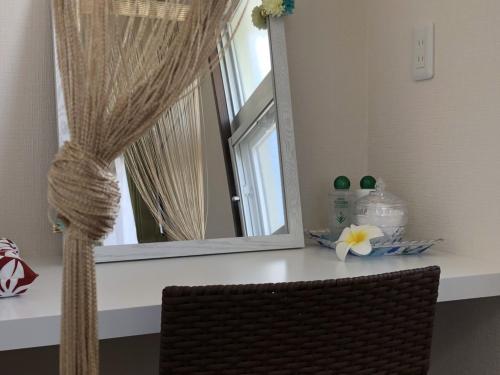 a mirror sitting on top of a counter in a room at TerraceRin YN31 in Tomigusuku