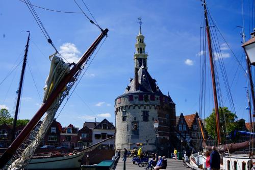 ein Gebäude mit einem Uhrturm neben einem Hafen in der Unterkunft Appartementen in het centrum van Hoorn in Hoorn