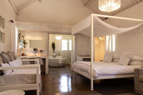 een slaapkamer met een hemelbed en een badkamer bij Conductor's Inn in Tsumeb