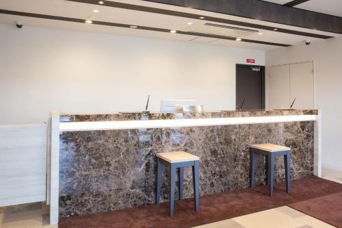 a bar in a room with two stools at Kuretake Inn Nankai Sakai-Ekimae in Sakai