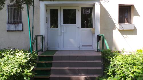 a white door of a house with stairs leading to it at Robert 's apartament in Ploieşti