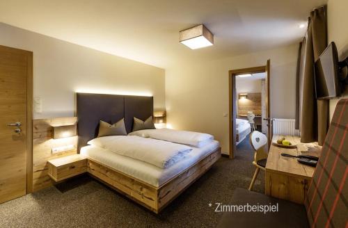 een slaapkamer met een groot bed met een bureau en een bed sidx sidx sidx sidx bij Gasthaus-Pension Herberger in Kurort Oberwiesenthal