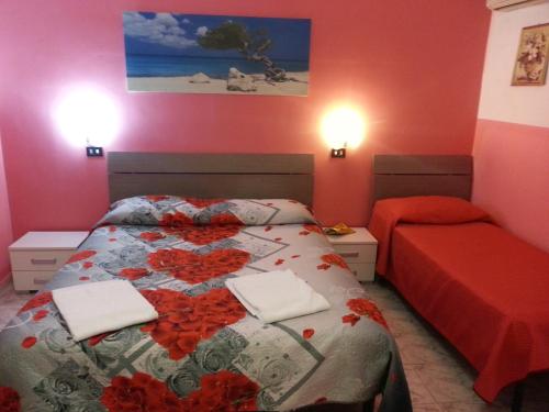a bedroom with a bed with red flowers on it at Roxena house in Rome