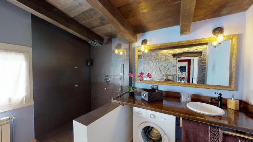 a bathroom with a sink and a washing machine at Casa Rural La Abadia-Apartamentos in Graus
