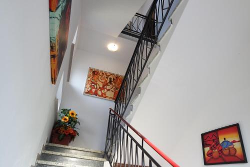 a set of stairs with paintings on the walls at Le Terrazze Rooms & Studios in Ferrara