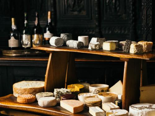 a display of different types of cheeses and bottles of wine at Longueville Manor in Saint Helier Jersey