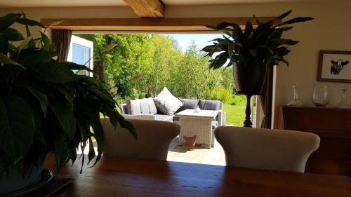 a living room with a couch and a potted plant at Keepers Cottage Guest House in Holt