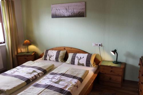 a bedroom with two beds and a lamp on a dresser at Haus am Rötenberg in Grafenhausen