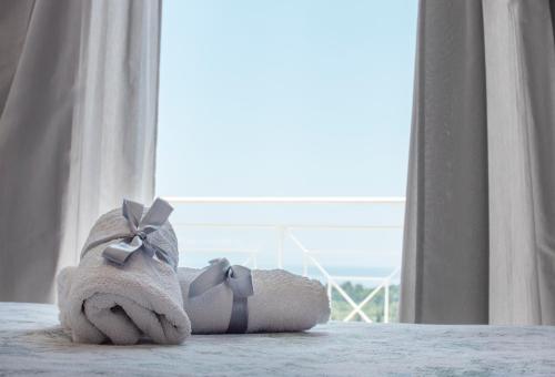 a stuffed animal is sitting on a bed with a window at Fiora Villas in Trapezaki