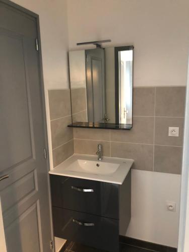 une salle de bain avec un lavabo et un miroir dans l'établissement Gîte proche du Puy du Fou, à Mortagne-sur-Sèvre