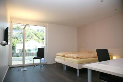 a bedroom with a bed and a table and chairs at Gasthaus Post in Willisau