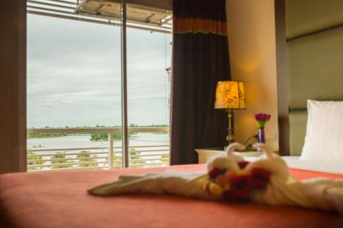 a bedroom with a bed with a view of a balcony at Kwan Ruen Park in Nakhon Ratchasima
