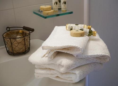 un montón de toallas sentadas en un mostrador en un baño en Locanda degli Alberi en Sassetta
