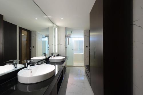 a bathroom with two sinks and two mirrors at K Hotel Taipei Dunnan in Taipei