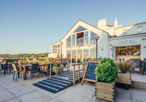 a restaurant with tables and chairs in front of a building at The Imperial Hotel in St Saviour Guernsey
