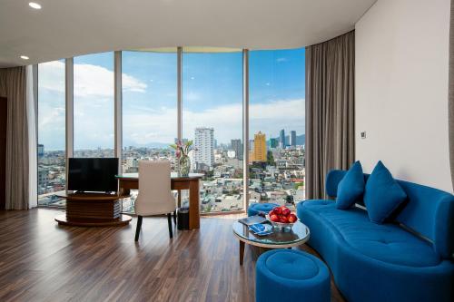 uma sala de estar com um sofá azul e uma mesa em Mitisa Hotel Da Nang em Da Nang