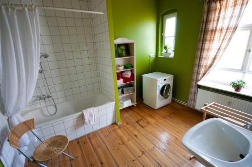 ein grünes Bad mit einer Badewanne und einem Waschbecken in der Unterkunft Ferienwohnung Fläming in Bad Belzig