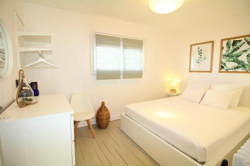 a white bedroom with a white bed and a desk at Villa Hyper Centre in Arcachon