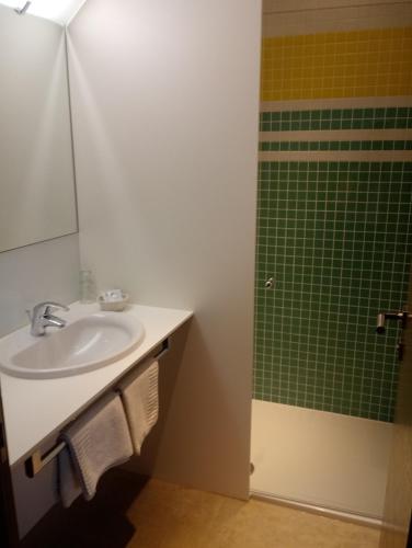 a bathroom with a sink and a green shower at Hotel Eisenhuthaus in Poysdorf