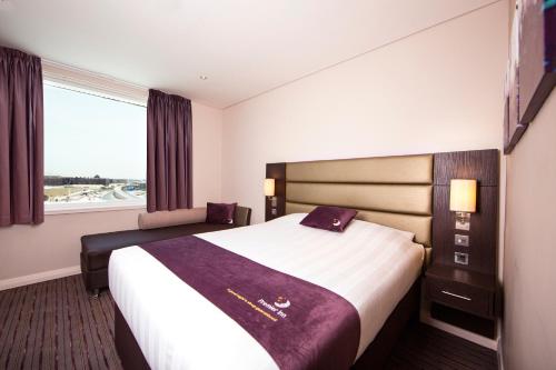 um quarto de hotel com uma cama grande e uma janela em Premier Inn Doha Education City em Doha
