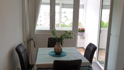 a dining room table with a vase on top of it at Fortuna Rajna Apartman in Split
