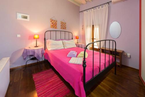 a bedroom with a pink bed with a pink blanket at Secret Garden Residence in Rhodes Town
