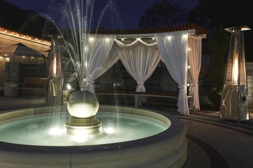 a fountain in the middle of a patio at night at Zacisze in Sokółka