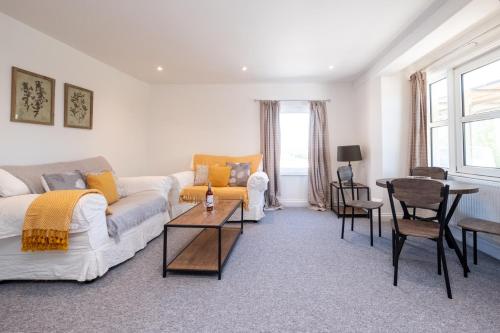 ein Wohnzimmer mit einem Sofa und einem Tisch in der Unterkunft Elm – Three Tuns Apartments in Pettistree