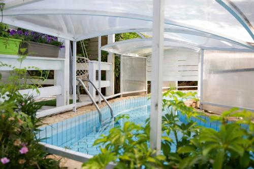 an outdoor swimming pool with an umbrella and a swimming poolvisor at Eili Suites in Moshav Ramot