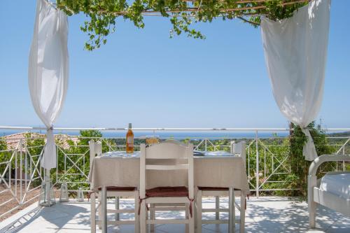 uma mesa com cadeiras e vista para o oceano em Fiora Villas em Trapezaki