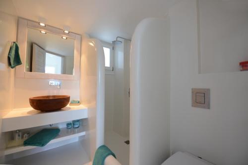 un baño con lavabo y espejo en Luxury White Maisonette, en Kalafatis