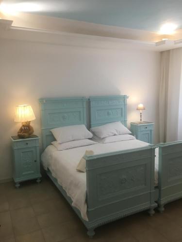 a bedroom with a blue bed with two night stands at Via Mazzini in Bazzano
