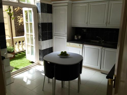 a kitchen with a table with a bowl of fruit on it at The Colonnade in London