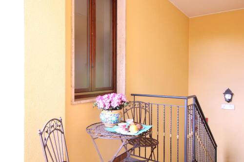 a small table with a vase of flowers on it at Hotel al Corso in Legnano