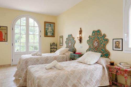 a bedroom with two beds and a window at Patio de los Gatos in Tamariu
