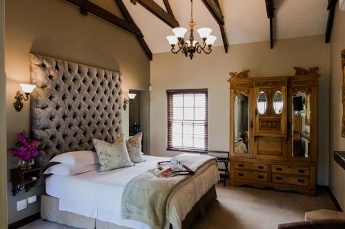 a bedroom with a large bed and a large headboard at Schoone Oordt Country House in Swellendam
