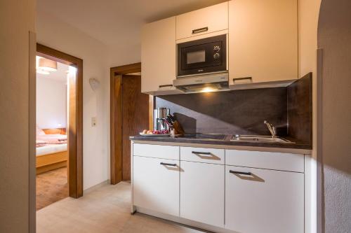 a kitchen with a sink and a microwave at Ferienwohnungen Hochfilzer in Ellmau