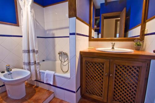 łazienka z umywalką, toaletą i lustrem w obiekcie Vivienda Casa Luisa w mieście Comillas