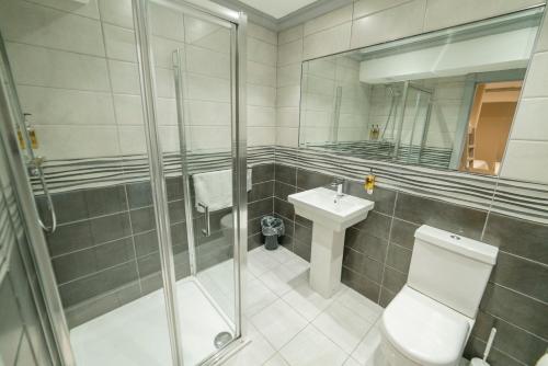 a bathroom with a shower and a toilet and a sink at Central Station Hotel Liverpool in Liverpool