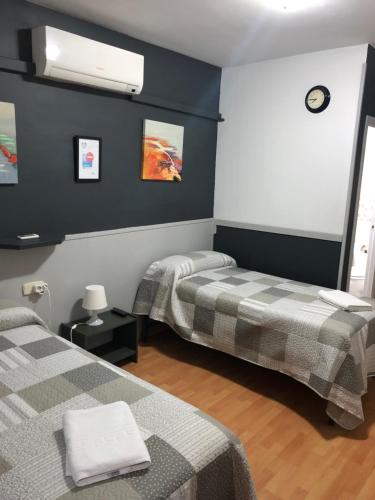 a room with two beds in a room at Hostal Restaurante Avenida de Madrid in Terrassa