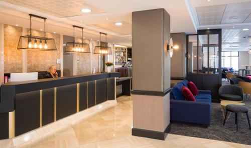 a man sitting at a bar in a lobby at Hôtel National in Lourdes
